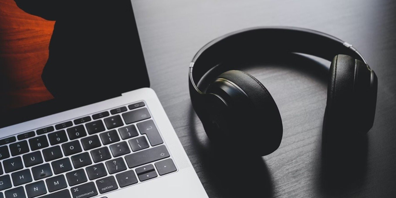 Headphones beside a computer.