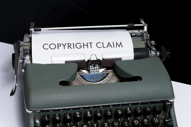 A piece of paper in a typewriter showing the phrase COYRIGHT CLAIM.
