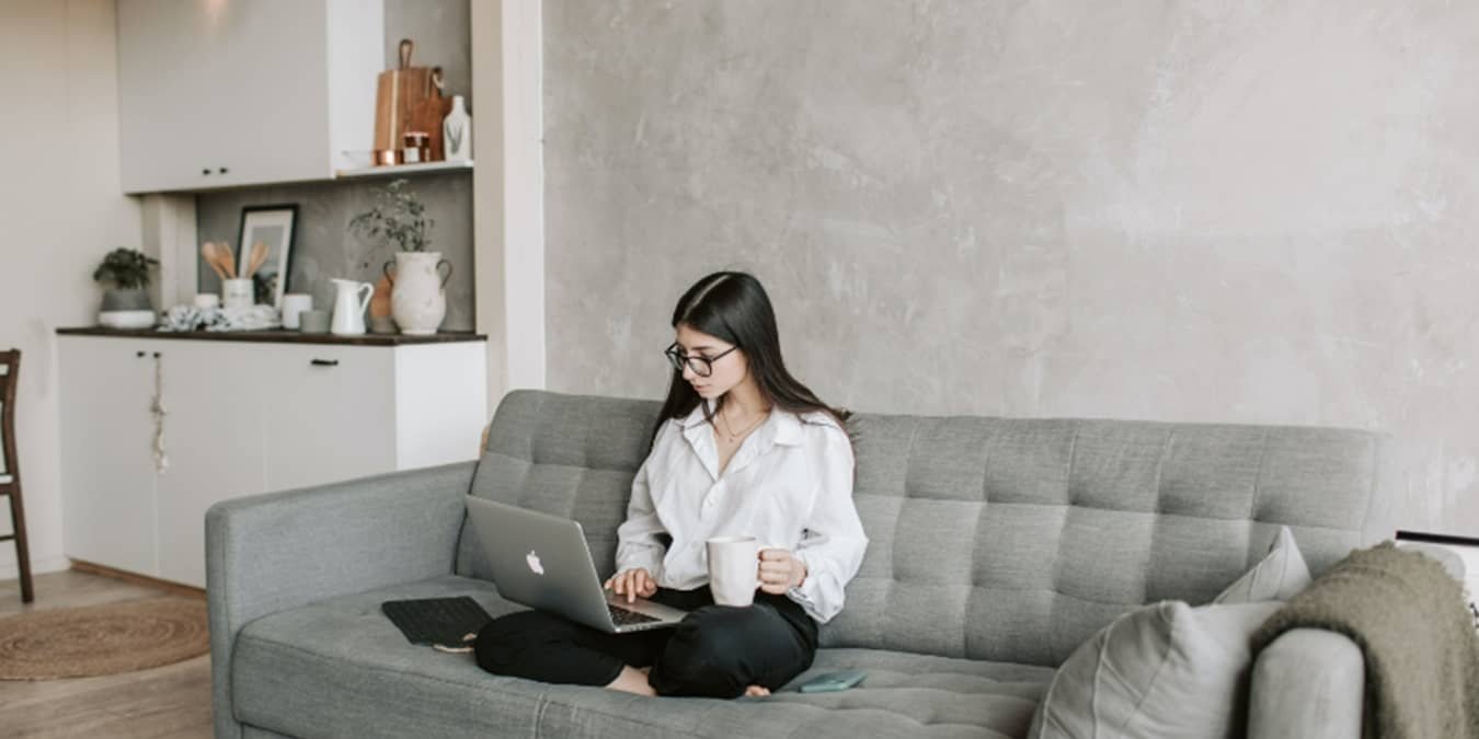 Women sitting on couch chatting with a chatbot.