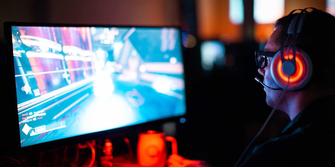 Man Playing Pc Game With Glowing Headphones On