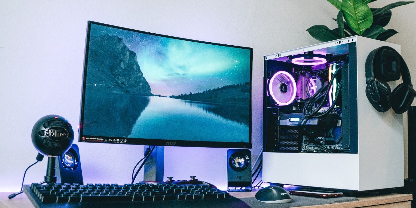 PC setup on desk with a monitor, gaming PC, and peripherals