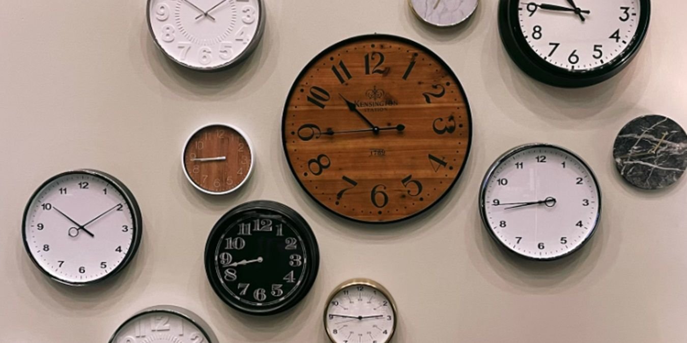 Group of analog clocks showing different times.