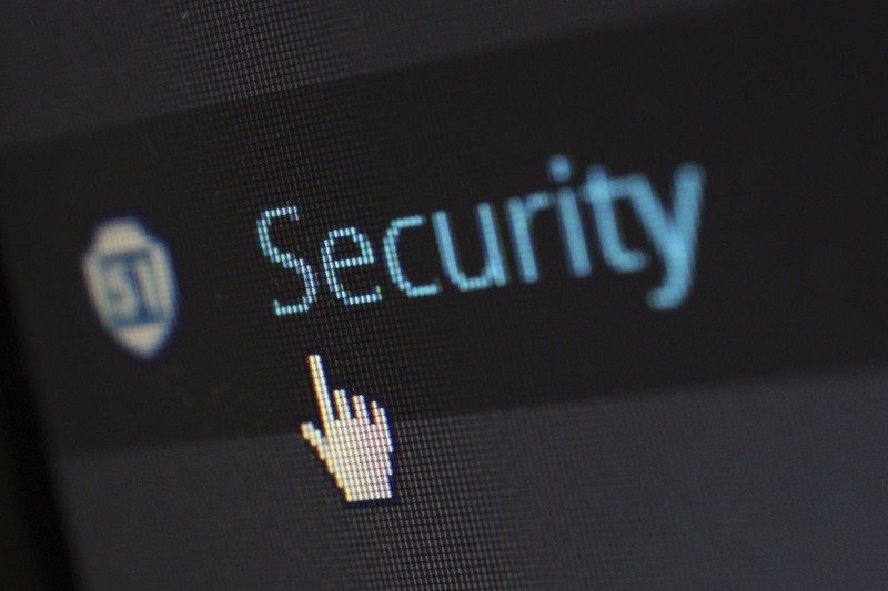 Close-up of a digital screen with a pixelated hand symbol pointing on the word Security.