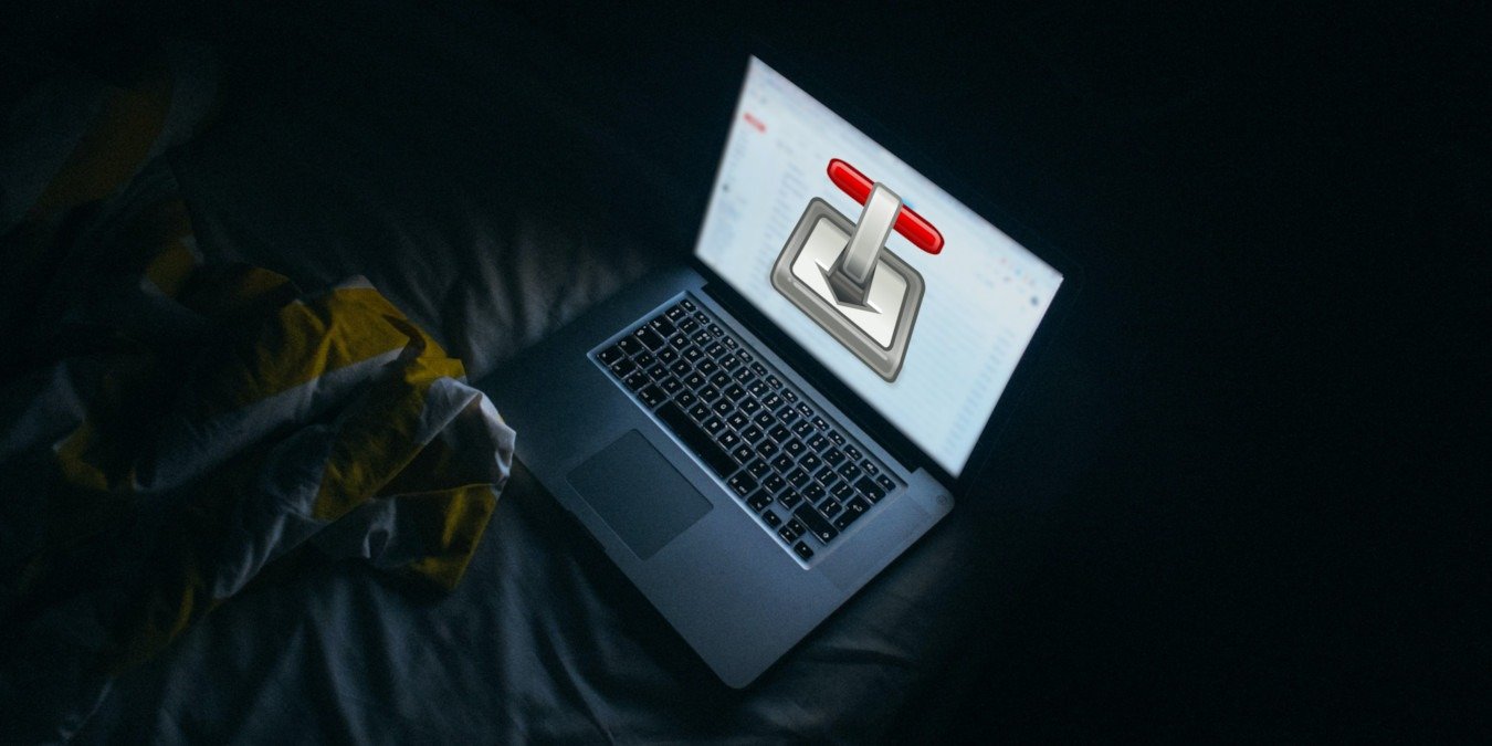 A photograph of a laptop on top of a bed.