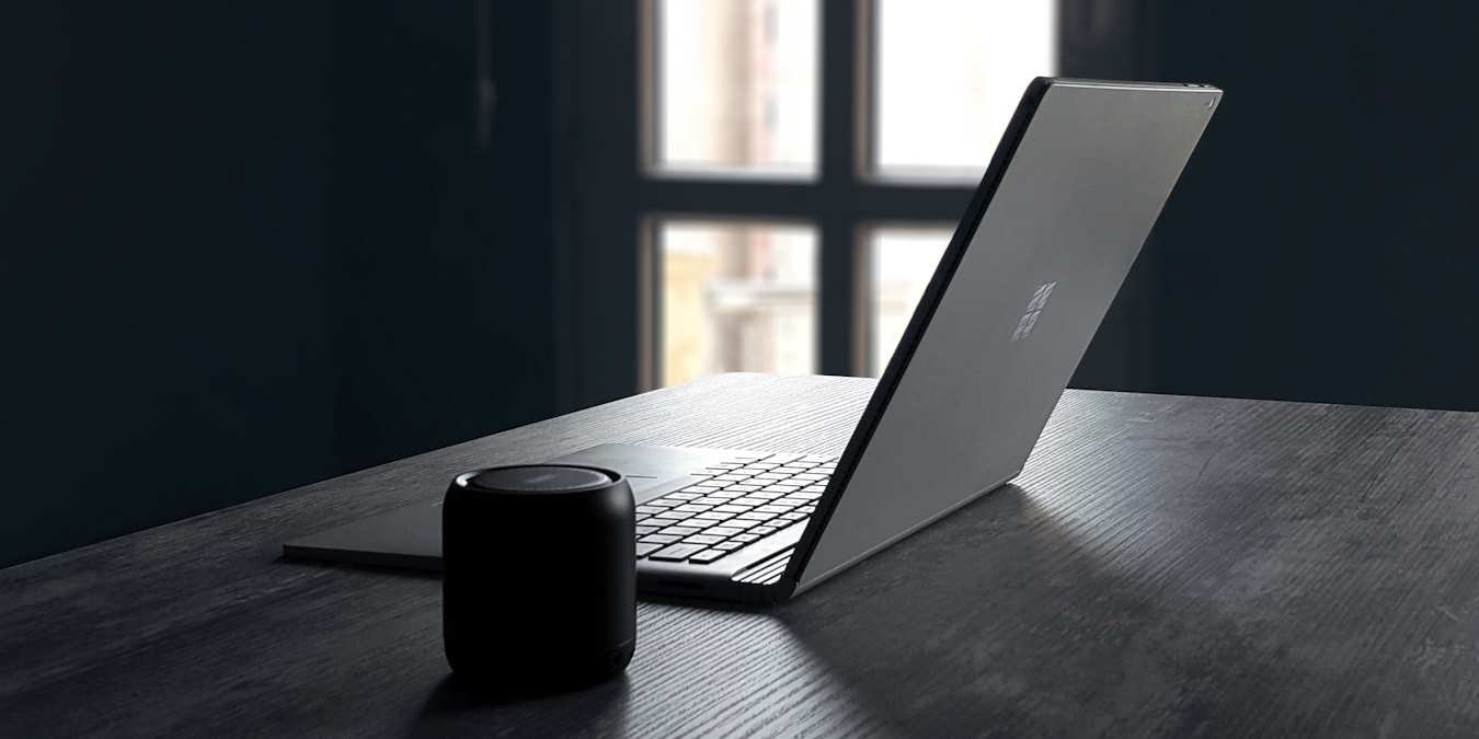 Windows Surface Laptop And Bluetooth Speaker On A Table